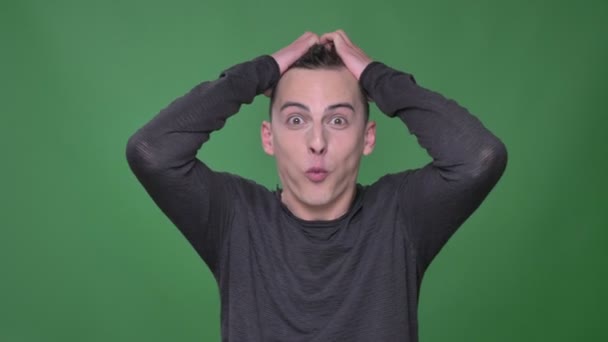 Closeup shoot of young handsome caucasian male being excited and happy looking straight at camera with background isolated on green — Stock Video