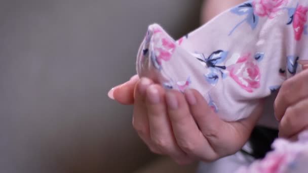 Primo piano della madre che tiene le gambe piccole del bambino nei cursori in soggiorno . — Video Stock