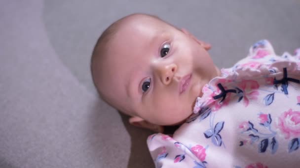Közelkép portré fiatal anya kezét a aranyos újszülött lányát fekszik a kanapén, és órák jobbra a nappaliban. — Stock videók
