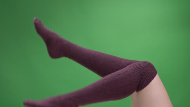 Closeup shoot of female teenage legs in cute red socks playfully moving with backround isolated on green — Stock Video