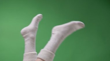 Sevimli kısa beyaz çoraplarda kadın genç bacaklar closeup üst ayak ateş oyun yeşil üzerinde izole artalanları ile hareket