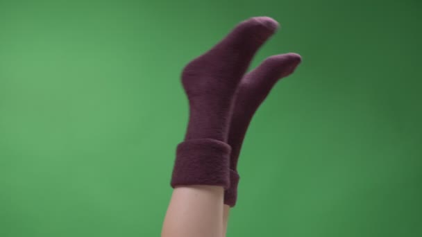 Closeup top láb lő a női tizenéves lábak aranyos rövid piros zokni játékosan mozog backround elszigetelt zöld — Stock videók