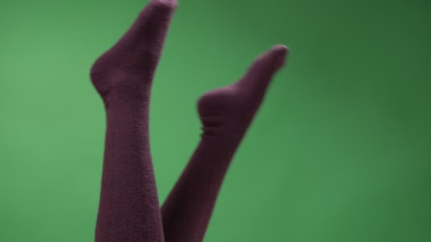 Closeup top láb lő a női tizenéves lábak aranyos piros térd zokni játékosan mozog backround elszigetelt zöld — Stock videók