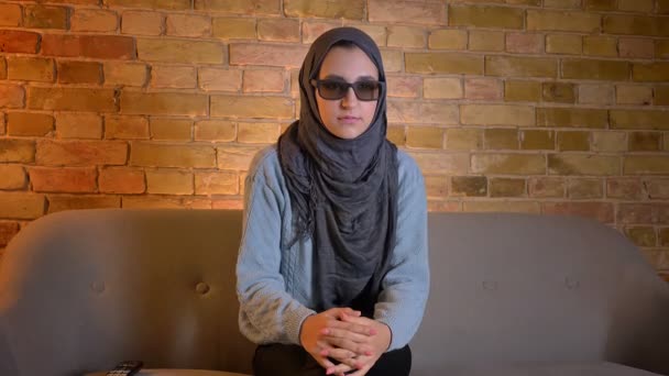 TV 'de bir 3D film izlerken hijab genç çekici Müslüman kadın closeup ateş ve rahat evde kanepede kapalı otururken bir jumpscare alma — Stok video