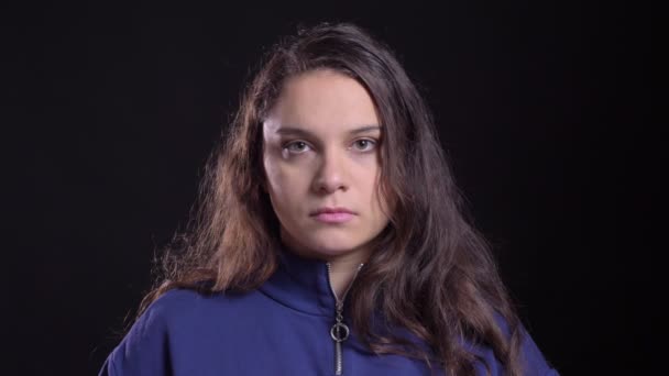 Närbild porträtt av vuxna attraktiva kaukasiska hona med lång brunett hår ser rakt på kamera med bakgrund isolerad på svart — Stockvideo