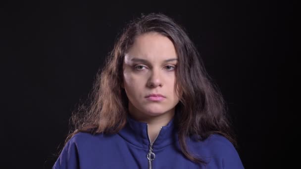 Gros plan portrait d'adulte attrayant caucasien femelle avec de longs cheveux bruns étant appareil photo triste et déçu avec fond isolé sur noir — Video