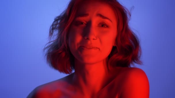 Closeup shoot of young attractive caucasian female smiling with excitement looking at camera with neon blue and red background — Stock Video