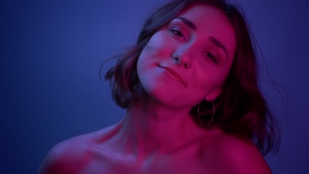 Closeup trage de tineri sexy de sex feminin zâmbind fericit uita-te la camera cu fundal albastru neon — Videoclip de stoc