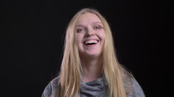 Portret van jonge blonde steil harige model lachen vreugdevol op zwarte achtergrond. — Stockvideo