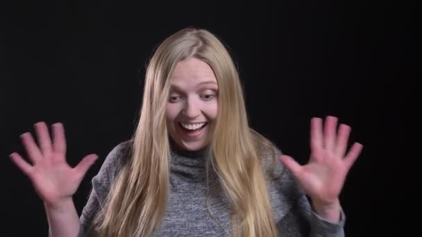 Portret van jonge blonde Straight-haired model toont extreme shock en geluk in de camera op zwarte achtergrond. — Stockvideo