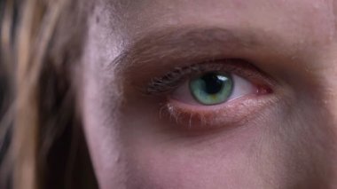 Siyah arka planda kamera içine sakince izlerken genç sarışın kadının yakın çekim göz-portre.