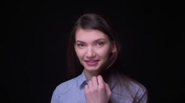 Kamera içine gülümseyen mavi bluz genç esmer işkadını portre ve siyah arka planda onunla flört.