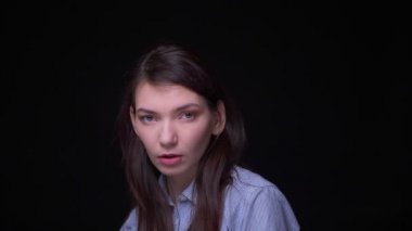 Mavi bluz genç esmer işkadını portre moda kamera içine siyah arka planda nazik omuz dokunmadan poz.