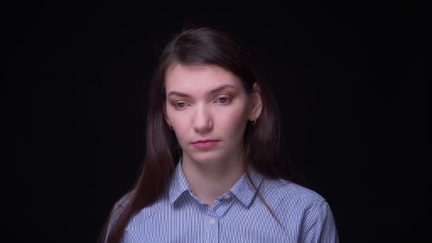 Brunette businesswoman in blue blouse watching thoughtfully and attentively into camera at black background. — Stock Video