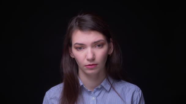 Brunette zakenvrouw in blauwe blouse kijken helaas en jammerlijk in de camera op zwarte achtergrond. — Stockvideo