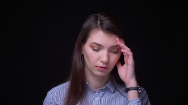Mulher de negócios morena em blusa azul assistindo tristemente sofrendo de dor de cabeça severa em fundo preto . — Vídeo de Stock