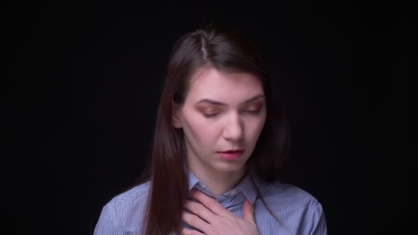 Брюнетка бизнесвумен в голубой блузке кашляет, страдая от сильного боли в горле на черном фоне . — стоковое видео