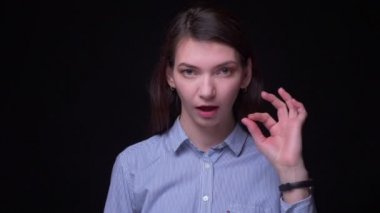 Güzel esmer işkadını mavi bluz işaret ok işareti her şeyi göstermek için serin ve ince siyah arka plan.