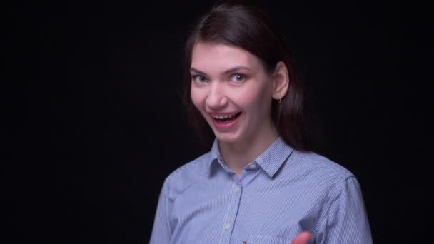 Портрет молодої брюнетки-бізнесу в синій блузці жестикулюючий знак пальця, щоб показати все добре на чорному тлі . — стокове відео