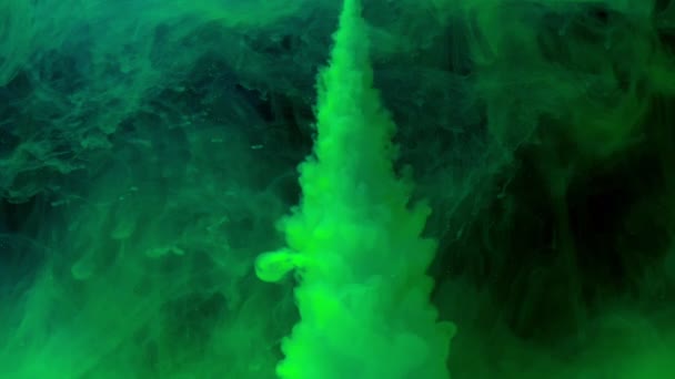 Tinta de pintura de color verde que vierte en agua en cámara lenta sobre fondo negro con nube de tinta girando y explosión de humo abstracto . — Vídeo de stock