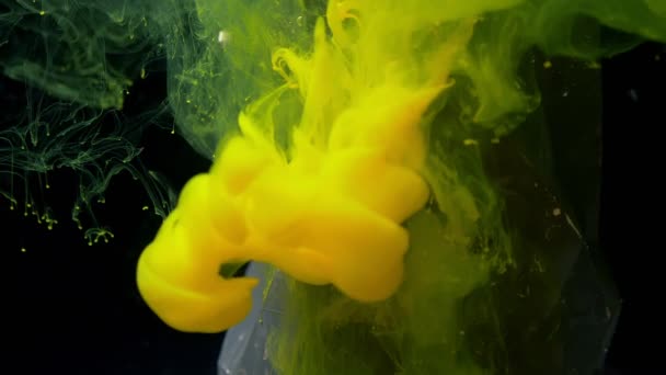 Figura abstracta de pie bajo el agua y tinta de pintura de color amarillo que vierte desde arriba cubre todo sobre fondo negro . — Vídeo de stock