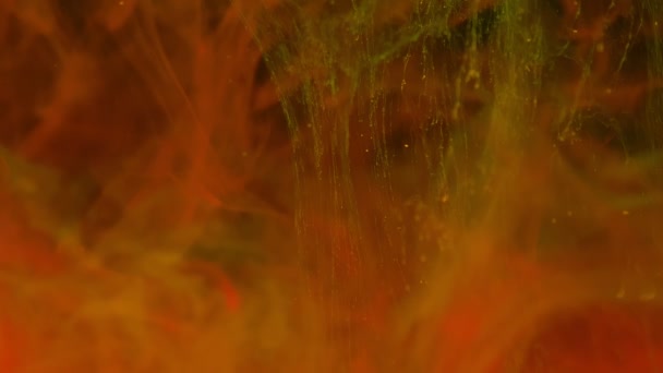 Червоно-жовті кольорові фарби вибухують у воді при повільному русі на чорному тлі з некрасивими хмарними завитками та абстрактним димом . — стокове відео