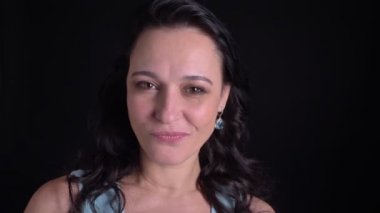 Siyah arka planda kameraya gizlice orta yaşlı güzel uzun saçlı kadının yakın çekim portre.