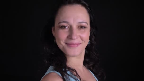 Ritratto di profilo di donna di mezza età si rivolge alla macchina fotografica e guarda con sorriso flirtare in macchina fotografica su sfondo nero . — Video Stock