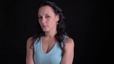 Siyah arka planda kamera düşünceli izlerken Orta yaşlı güzel uzun saçlı kadın portre.