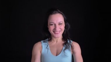 Heyecan verici orta yaşlı güzel kadın mutlu izlerken ve aktif siyah arka planda hareketli portresi.