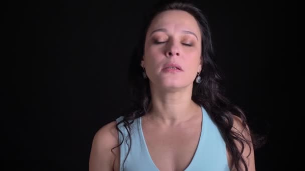 Porträt einer brünetten Frau mittleren Alters, die an Gebrechen leidet und versucht, auf schwarzem Hintergrund zu atmen und sich zu beruhigen. — Stockvideo
