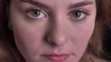 Siyah arka planda kamera ciddiye izlerken güzel sarışın kadının yakın çekim portre.