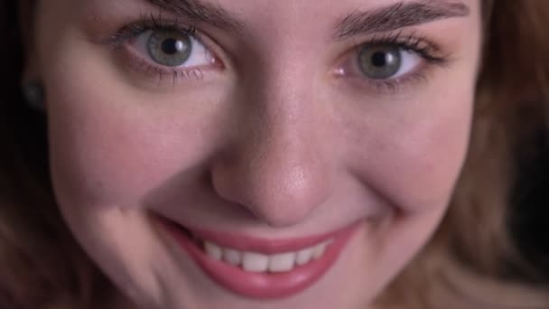 Close-up portrait of beautiful blonde woman watching into camera and showing extreme happiness on black background. — Stock Video