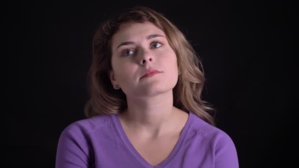 Портрет грустной белокурой белокурой женщины, которая думает в разочаровании на черном фоне . — стоковое видео