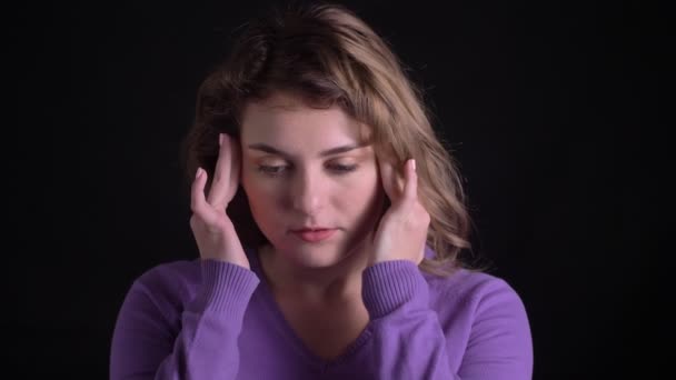Portret van verdrietig blonde Kaukasische vrouw het maken van massage van hoofdpijn op zwarte achtergrond. — Stockvideo