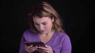 Tablet ile çalışan kadın portresi siyah arka planda büyük bir şok alır.