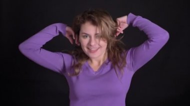 Sevimli sarışın beyaz kadın portre aktif ve garip siyah arka planda dans.