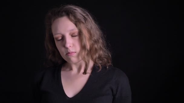 Porträtt av allvarliga unga Curly-haired flicka tittar med irritation i kameran på svart bakgrund. — Stockvideo