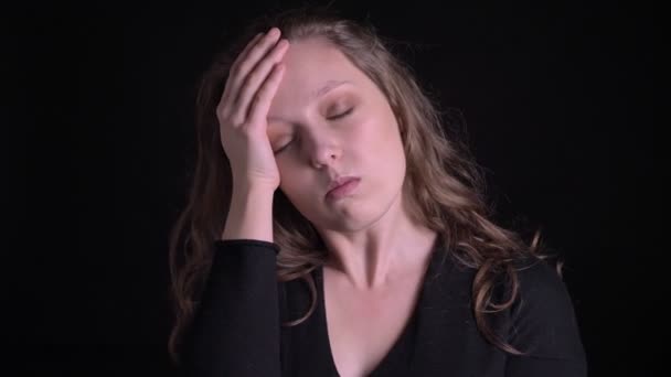 Portré fiatal göndör hajú lány megérintette a fejét szenved fejfájás fekete háttér. — Stock videók