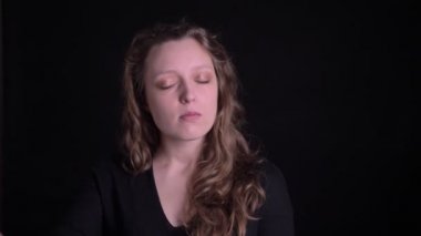 Siyah arka plan üzerinde memnuniyeti ile yavaşça dans genç kıvırcık saçlı kız portre