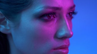 Renkli neon ışıklar kozmik moda modeli stüdyoda sabit sağa izliyor.