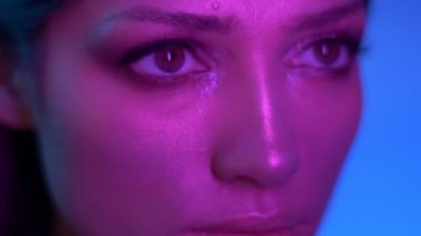 Mor neon ışıklar kozmik moda modeli yavaş hareket ve stüdyoda dikkatle ve sakince sağa izlerken.