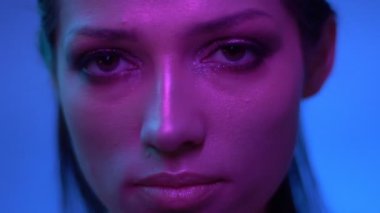 Mor neon ışıklar Fabulous model yavaş hareket ve stüdyoda kamera içine sakince izliyor.