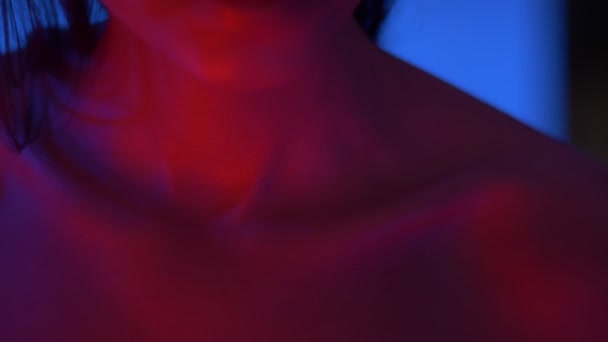 Primer plano de clavícula y labios de modelo futurista de moda en luces de neón de color rojo brillante en estudio . — Vídeos de Stock