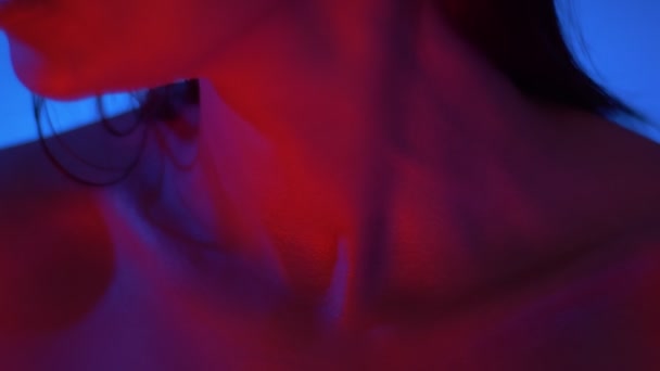 Primer plano de clavícula y barbilla de modelo futurista y sexy en luces de neón de color rojo brillante en el estudio . — Vídeos de Stock