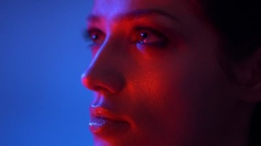 Kırmızı neon ışıklar glitter göz gölgeleri ile fantastik moda modeli nin yakın çekim yüzünü ellerini hareket