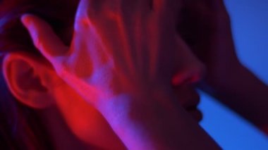 Kırmızı neon ışıklar fantastik moda modeli profilinde yakın çekim portre saçlarını ile eller çalışır.