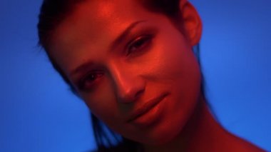 Kırmızı ve mavi neon ışıklar memnuniyet gözlerini kapatan moda modelinin yakın çekim.