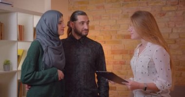 Genç mutlu Müslüman çift in closeup ateş yeni bir daire kapalı neşeyle gülümseyen yeni bir daire ile tartışıyor