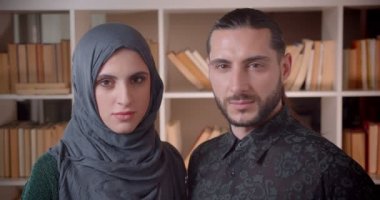 Kütüphanede kamera kapalı düz bakarak genç Müslüman iş kadını ve işadamı closeup çekim